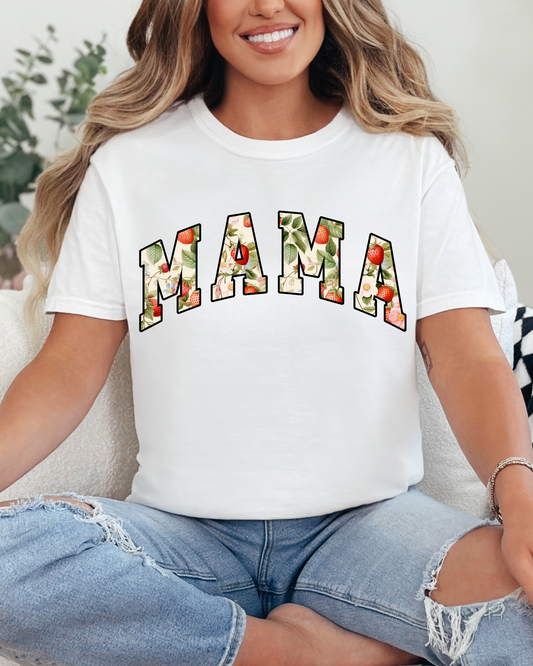 Woman wearing a white t-shirt with 'MAMA' printed on it, sitting on a couch.