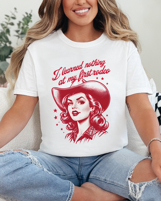 Woman wearing a white t-shirt with a graphic design and text, sitting on a couch.
