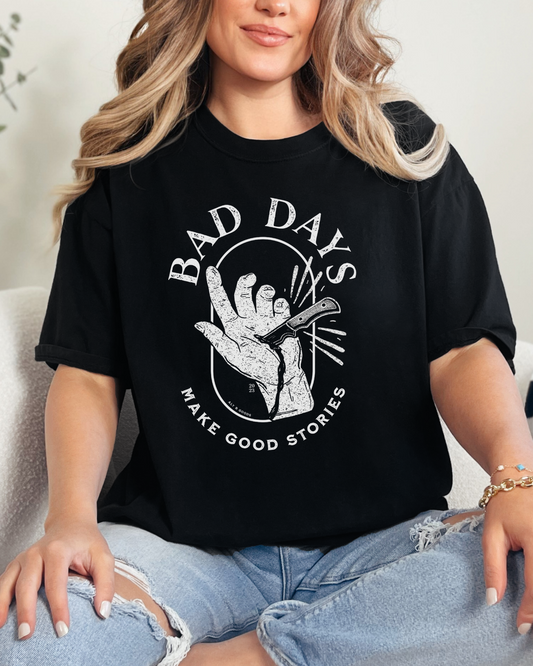 Woman wearing a black t-shirt with a graphic design sitting on a couch.