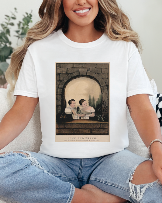 Woman wearing a white t-shirt with a graphic design sitting on a couch.