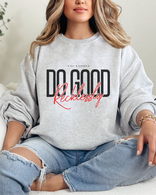Person wearing a gray sweatshirt with text, sitting on a couch.